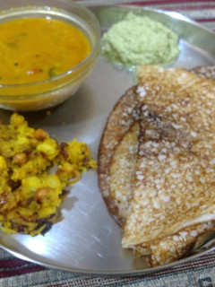 A picture of Bread and cooked rice masala dosa with sambhar and chutney.