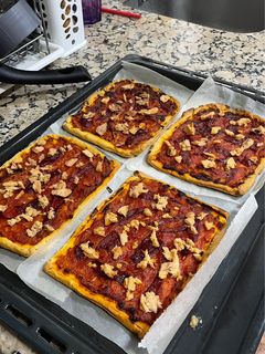 Una foto de Coca casera con tomate y atún