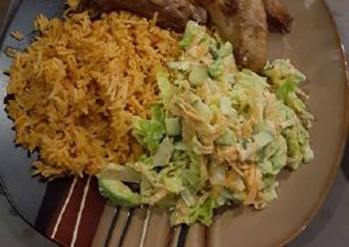 Jollof rice with salad and chicken wings