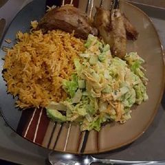 A picture of Jollof rice with salad and chicken wings.