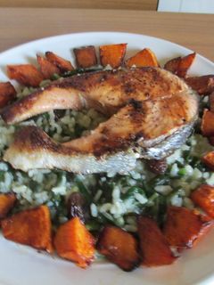 Una foto de Salmón sobre arroz verde con tacos de calabaza