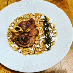Pork osso buco, saffron orzo, tangerine gremolata and feta A picture of Pork osso buco, saffron orzo, tangerine gremolata and feta.