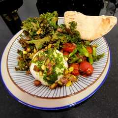 Una foto de Ensalada de burrata con kale crujiente, tomates y espárragos asados y aliño de albahaca con miel