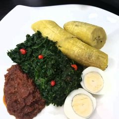 A picture of Unripe plantain with tomato sauce,vegetable and egg.