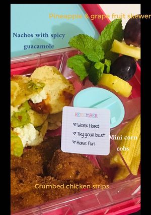 A picture of Nachos, crumbed chicken pieces, mini corn cobs, pineapple grape and mint fruit skewer.