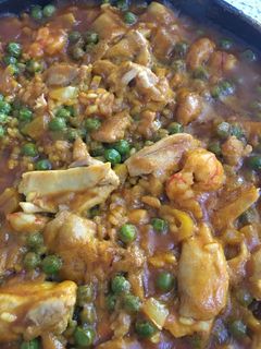 Una foto de Paella de pollo y gambón con guisantes
