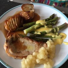A picture of Brined Pork Chops with Hasselback Potatoes, tender, buttery Asparagus and sharp Hollandaise Sauce.