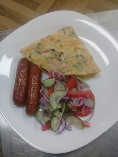 A picture of Spanish Omellette, deep fried sausages n cucumber onions salad.