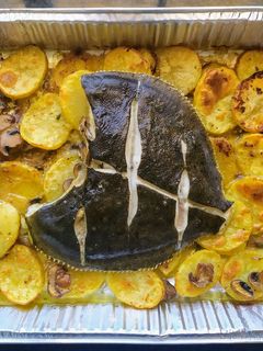 Una foto de Rodaballo al horno con guarnición