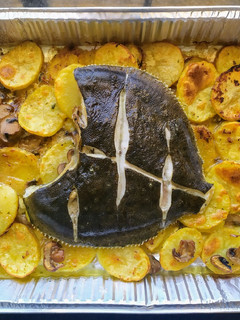 Una foto de Rodaballo al horno con guarnición