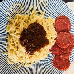 A picture of Noodles with peppersauce and salami.