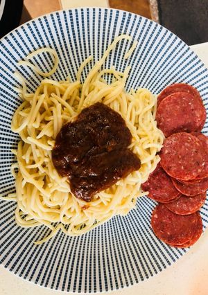 A picture of Noodles with peppersauce and salami.