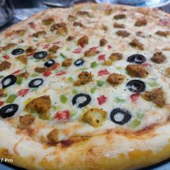 A picture of Chicken Tikka and veggies pizza.