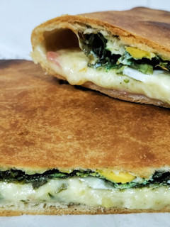 Una foto de Empanada de espinacas, bacon, mozzarella y huevos de codorniz