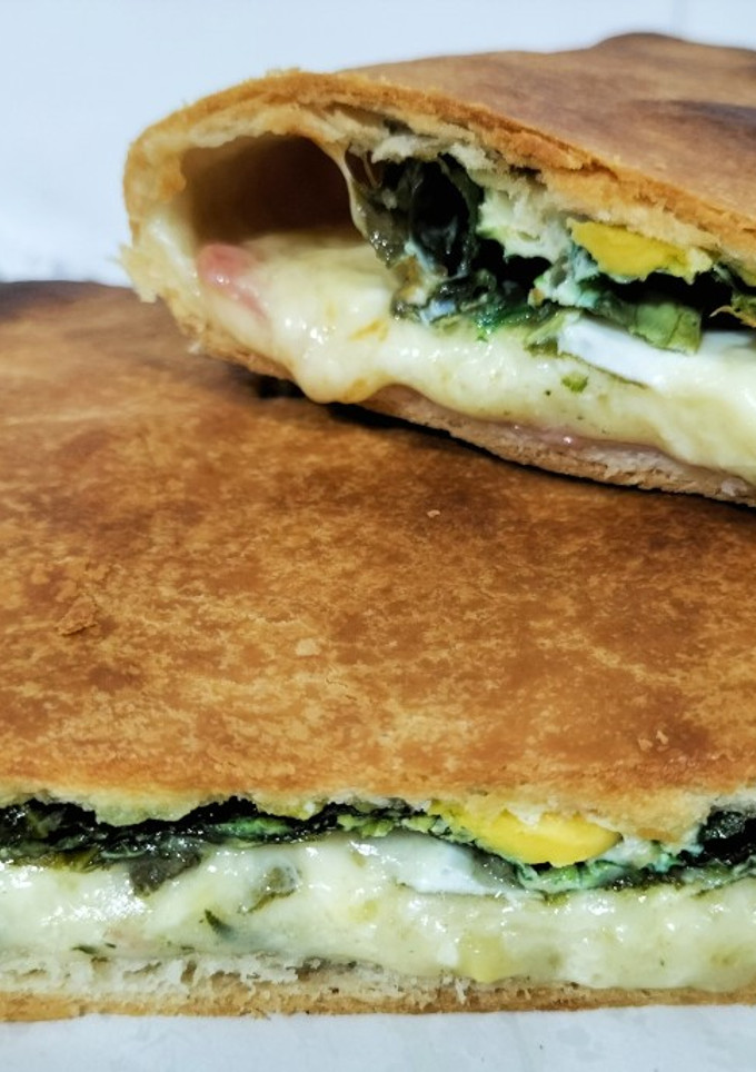 Una foto de Empanada de espinacas, bacon, mozzarella y huevos de codorniz