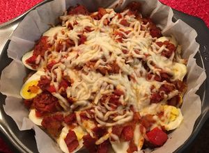 Una foto de Huevos duros con papas tomate y queso