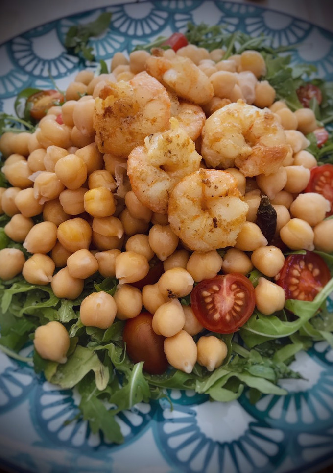 Una foto de Ensalada de garbanzos y rúcula con langostinos