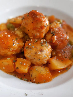 Una foto de Albóndigas de merluza en salsa con patatas y guisantes