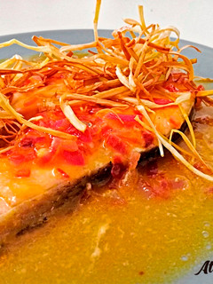 Una foto de Salmón en salsa de naranja con tiras de puerro crujientes