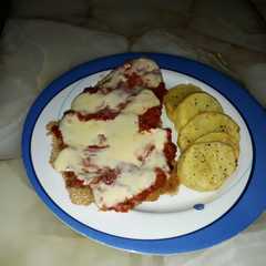 Una foto de Milanesa napolitana con papas al horno
