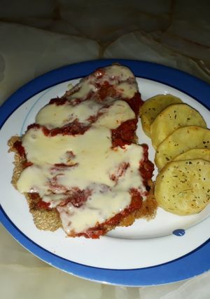Una foto de Milanesa napolitana con papas al horno