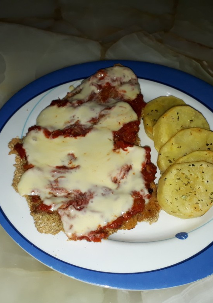 Una foto de Milanesa napolitana con papas al horno