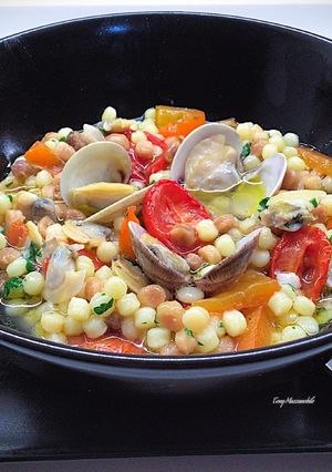 A picture of Fregola Sarda with Clams, Bell Pepper, and Roasted Datterini Tomatoes.