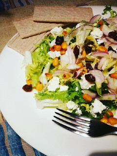Una foto de Escarola con queso Feta, uvas pasas y maíz crujiente