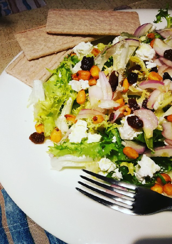 Una foto de Escarola con queso Feta, uvas pasas y maíz crujiente