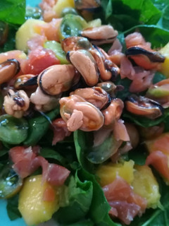 Una foto de Ensalada de espinacas frescas con mango, salmón y mejillon