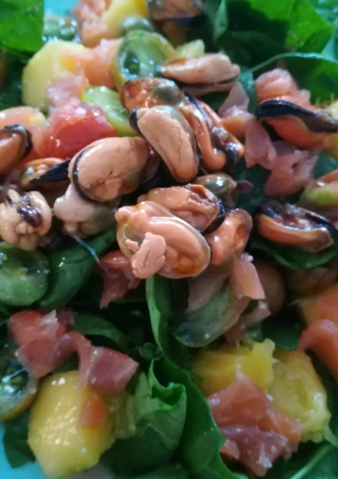 Una foto de Ensalada de espinacas frescas con mango, salmón y mejillon