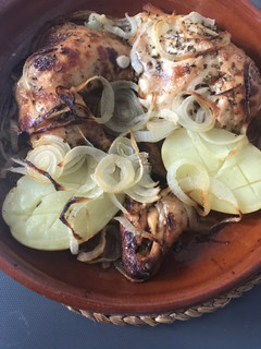 Una foto de Medio pollo asado con patatas y cebolla