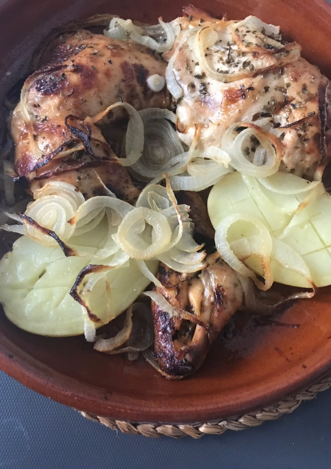 Una foto de Medio pollo asado con patatas y cebolla