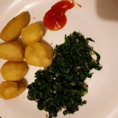 A picture of Tumeric roast potatoes served with spinach.