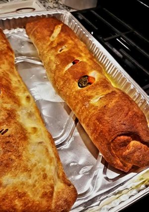 A picture of Sausage Pepper & Broccoli Rabe Calzone with Roasted Peppers & Mozzarella.