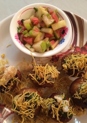 A picture of Aloo Puri with cut fruits.