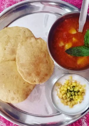 A picture of Potato Mint Tomato Curry with Puri & Boondi Raita.