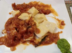 Una foto de Saquitos de cangrejo y ricota en salsa de langostinos y albahaca