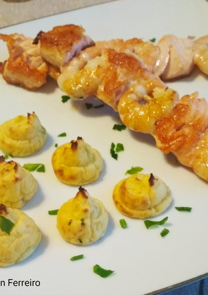 Una foto de Patatas duquesa con brochetas de salmón y langostinos
