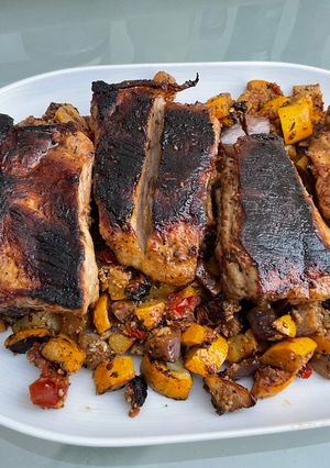 Une photo de Travers de porc marinés aux courgettes jaunes, aubergine graffiti et tomates