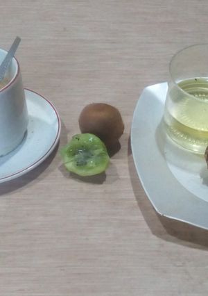Una foto de Cafe con leche descremada más tostada con aceite más kiwi