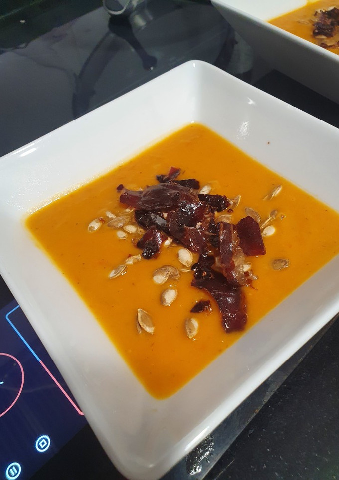 Una foto de Crema de verduras asadas con pipas y jamón crujientes