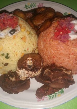 A picture of Fried rice and jollof with fried plantain and fried chicken.