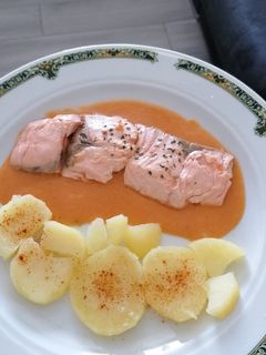 Una foto de Salmón sobre bisqué de gambas y patatas panaderas con paprika