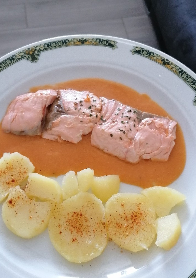 Una foto de Salmón sobre bisqué de gambas y patatas panaderas con paprika