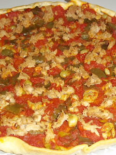 Una foto de Coca de masa brisa con tomate, pimiento y atún