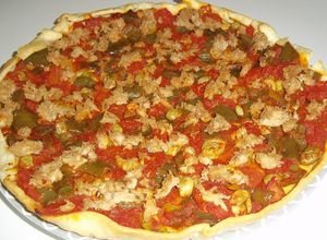 Una foto de Coca de masa brisa con tomate, pimiento y atún