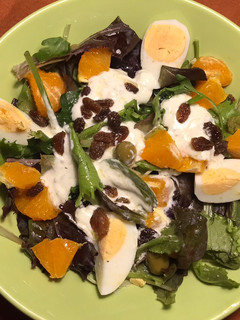 Una foto de Ensalada de brotes tiernos, con salsa de queso Roquefort, pasas y mandarina