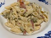 Una foto di pasta con speck panna