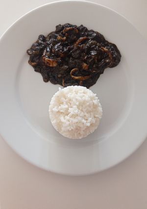 Una foto de Calamares en tinta con arroz blanco